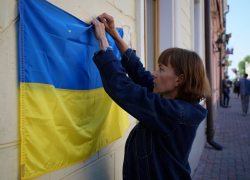 В Одессе женщина сорвала флаг Украины с магазина и бросила его в мусор